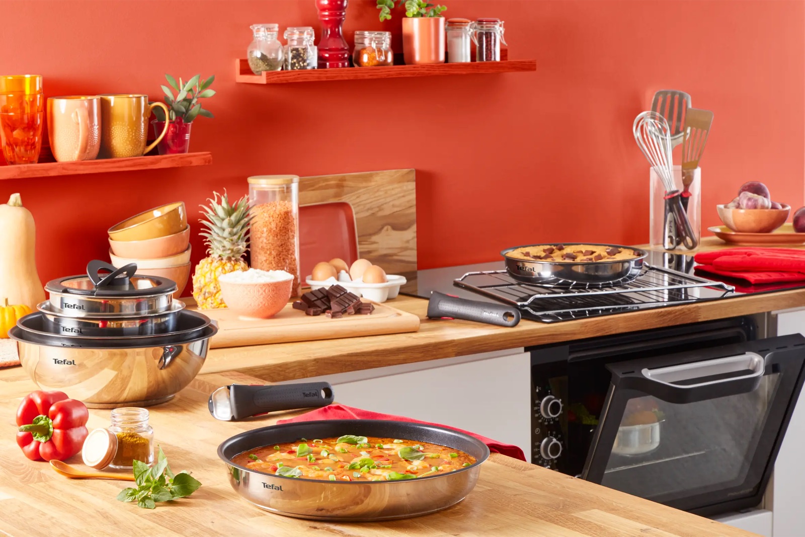 Cocina con las sartenes Ingenio Emotion en uso y el mango extraíble sobre la encimera